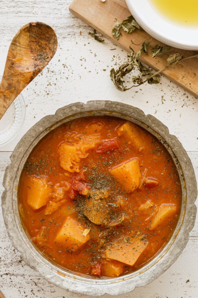 A warm bowl of vegetable stew with potatoes and herbs, perfect for comfort food lovers.